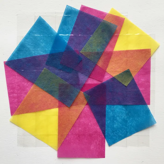 A butterfly-shaped sun catcher made from bright tissue paper hangs in a window.