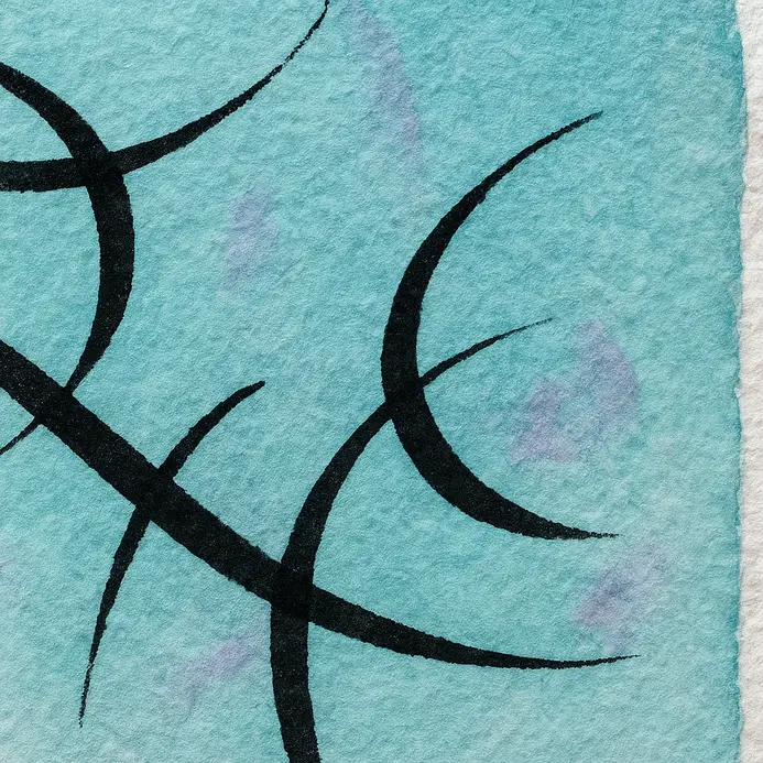A fine liner pen outlines the soft edges of a watercolor letterform.