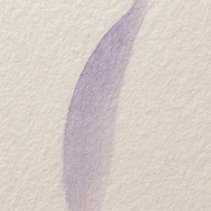A brush lifts with light pressure to form a delicate upstroke in lettering.