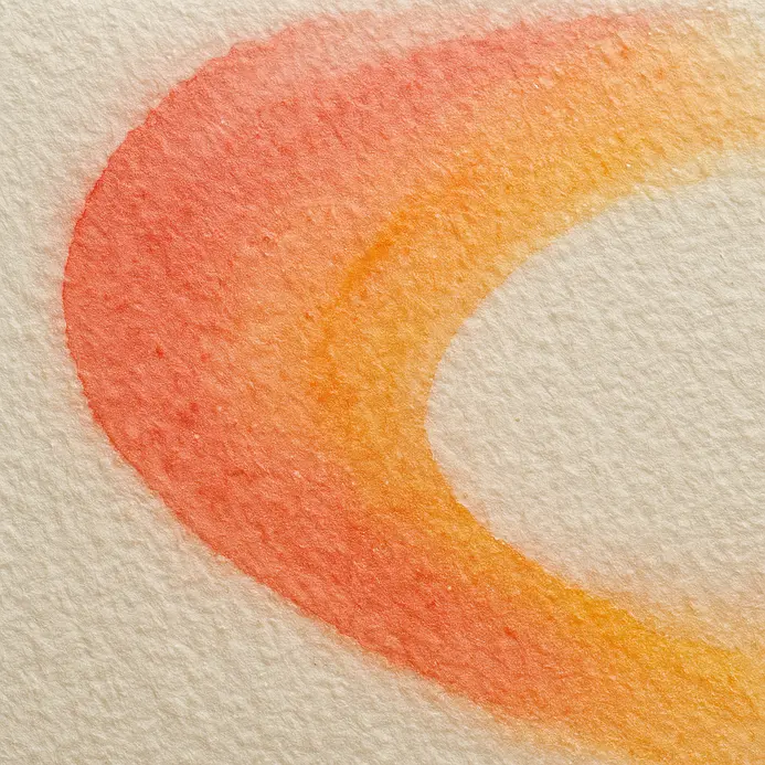 Pink and yellow watercolor blend seamlessly on a wet letterform.