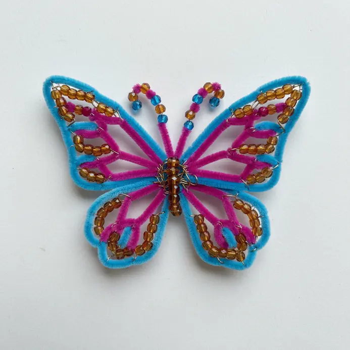 Colorful pipe cleaners bent into wing shapes and decorated with small beads.