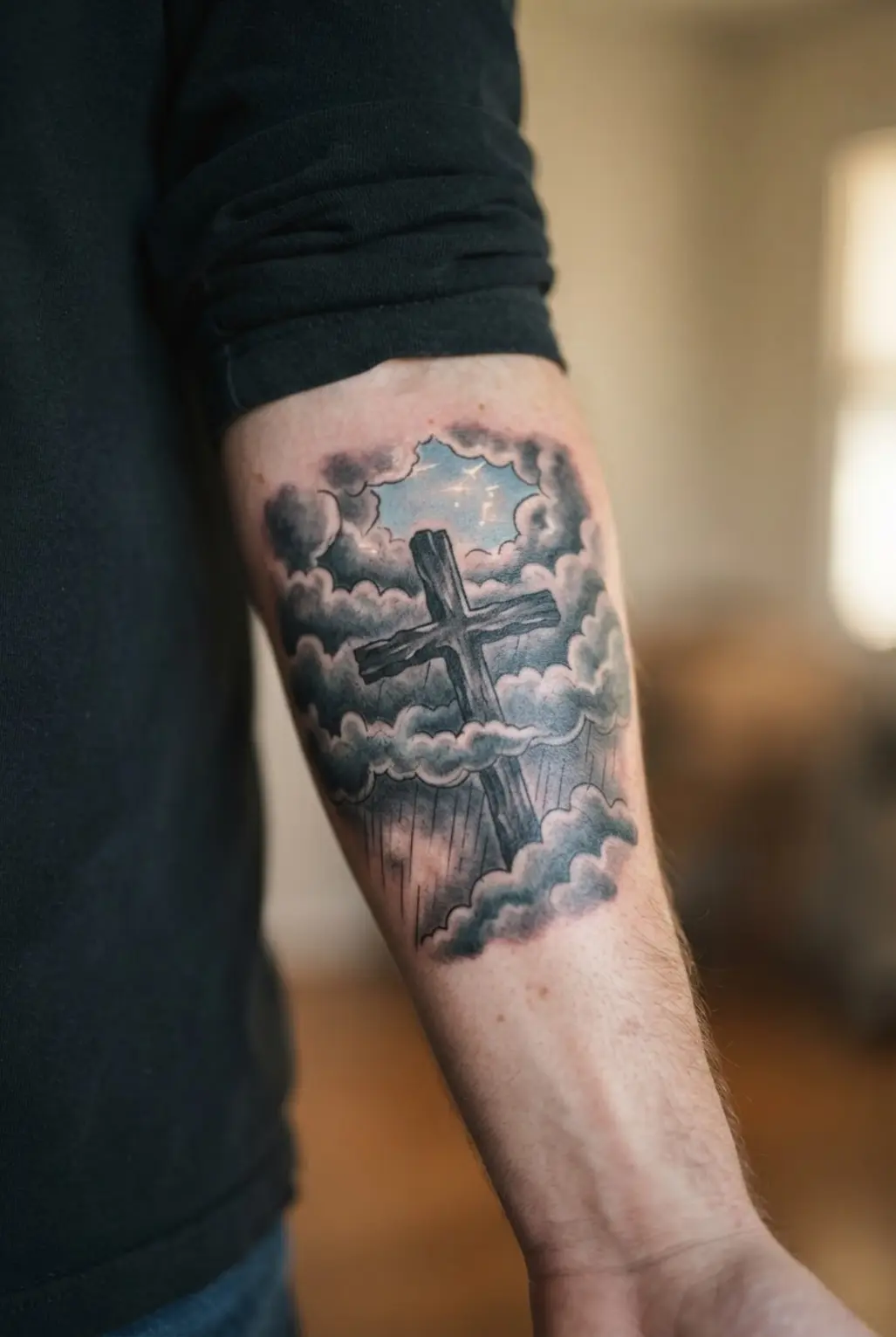 A dark cross rises through storm clouds on the forearm with rain lines, heavy shading, and a small open sky.