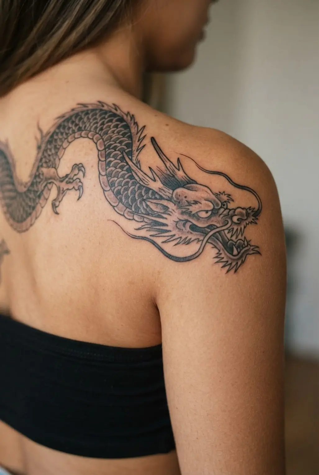 A bold dragon curves from the upper back around the shoulder with thick black lines.