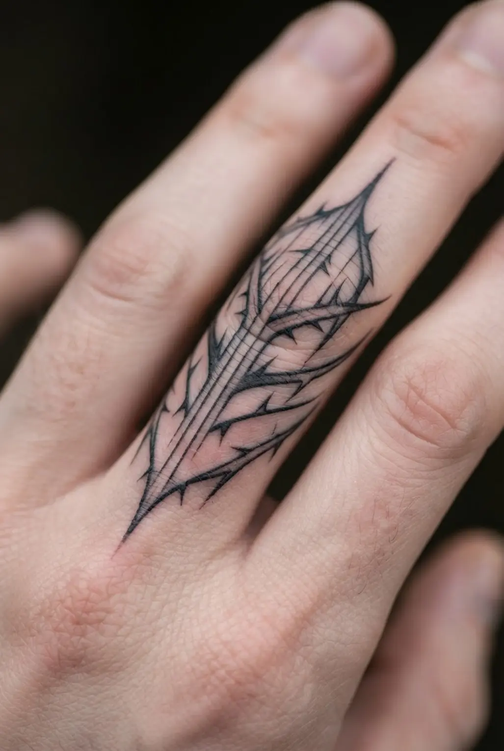 Minimalist black ink thorns extend across two fingers with thin lines and clear spacing.