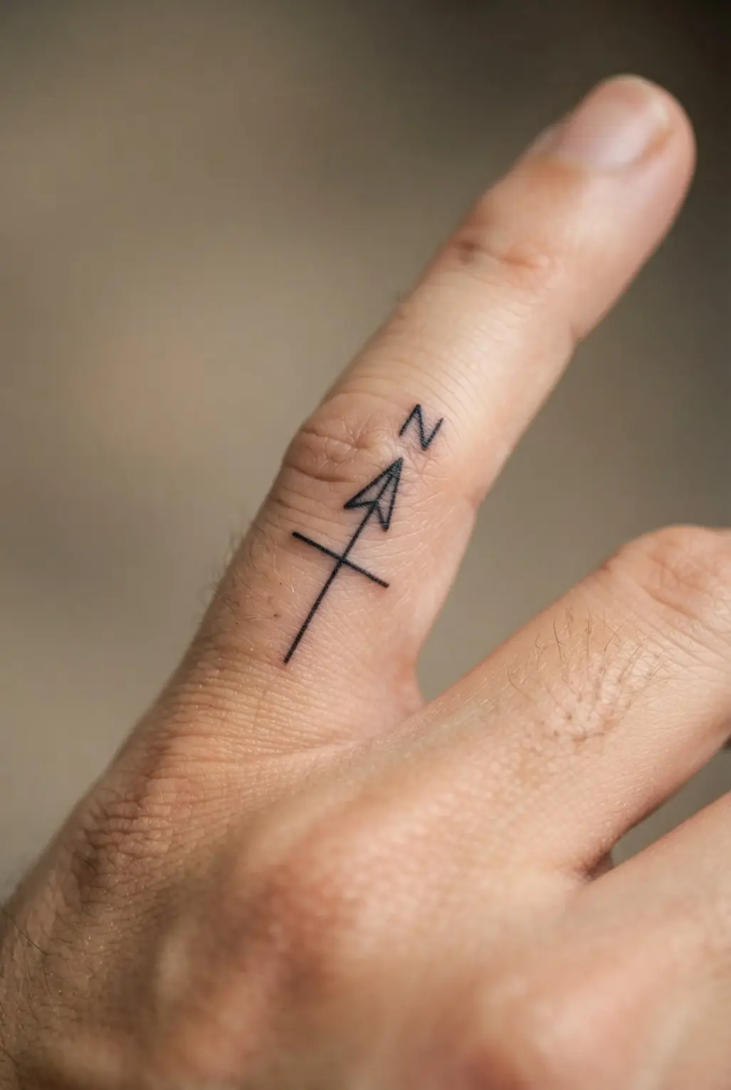 A compact compass arrow points upward on a finger with a simple central line and clear black outline.
