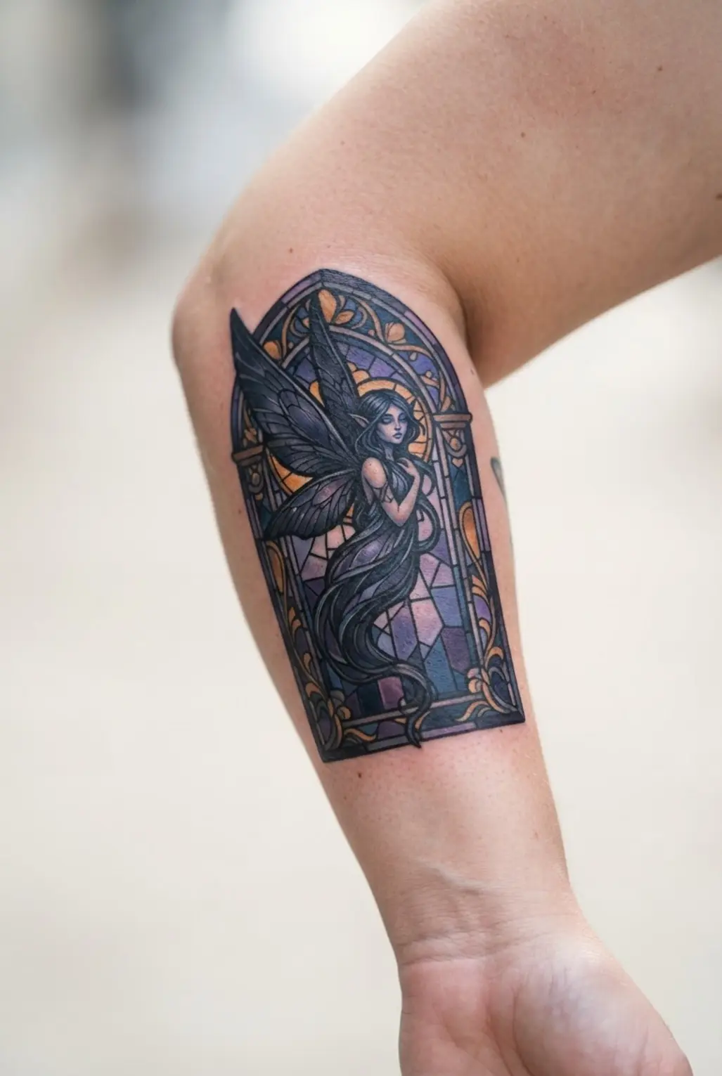 Gothic fairy tattoo designs feature a winged night sprite inside a stained glass frame.
