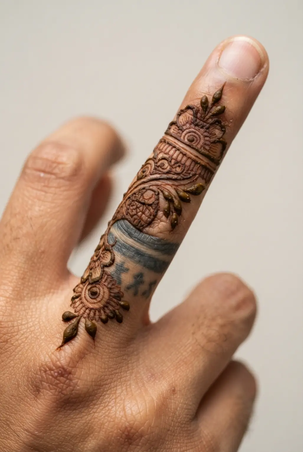 A temporary, artistic henna pattern transforming an old tattoo into a new, beautiful design.