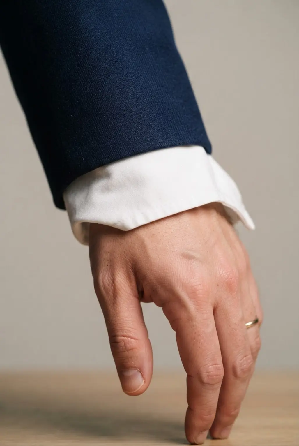 A professional blazer sleeve cuff worn over the hand for sophisticated, context-appropriate coverage.