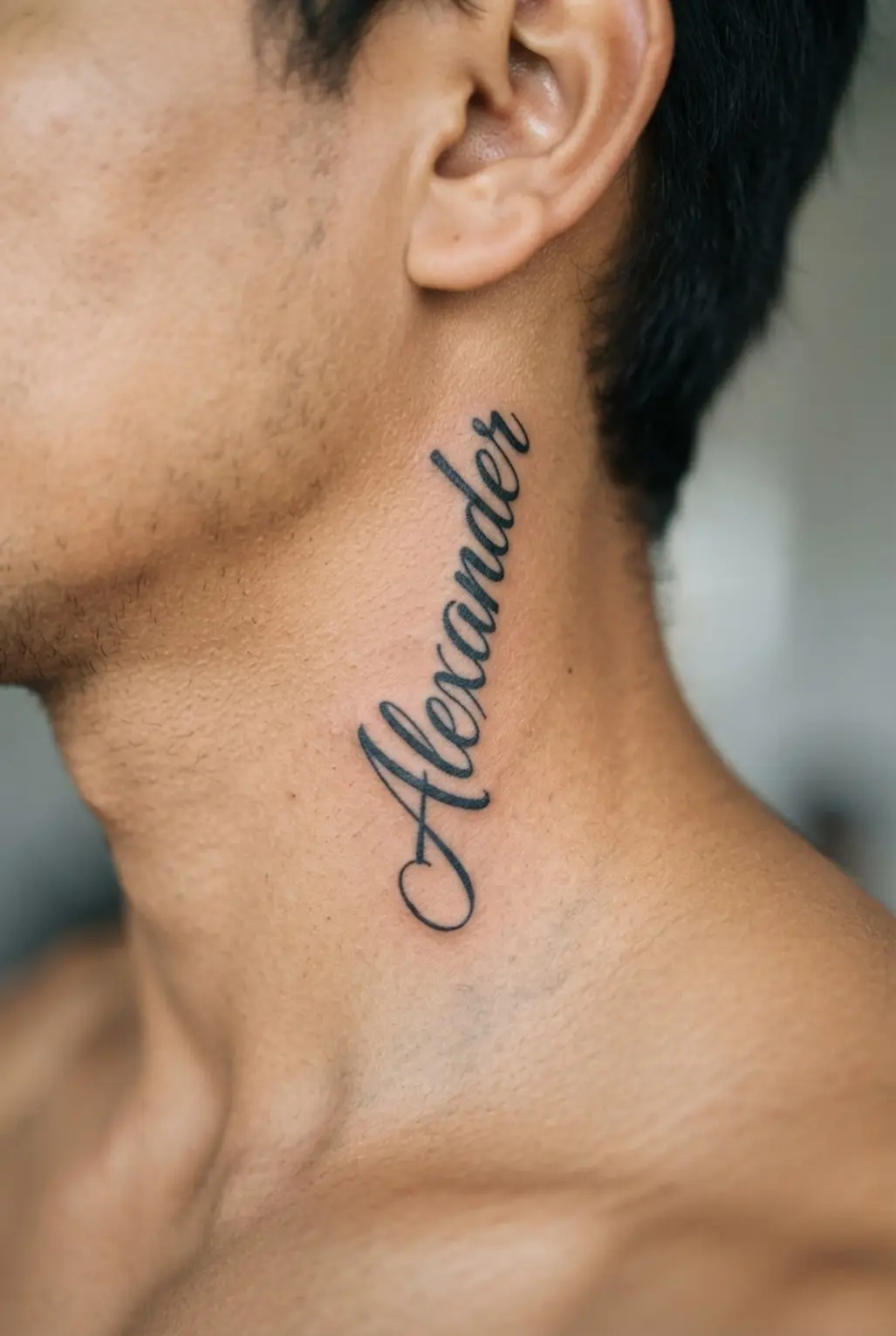 A meaningful script tattoo placed vertically on the side of the neck.