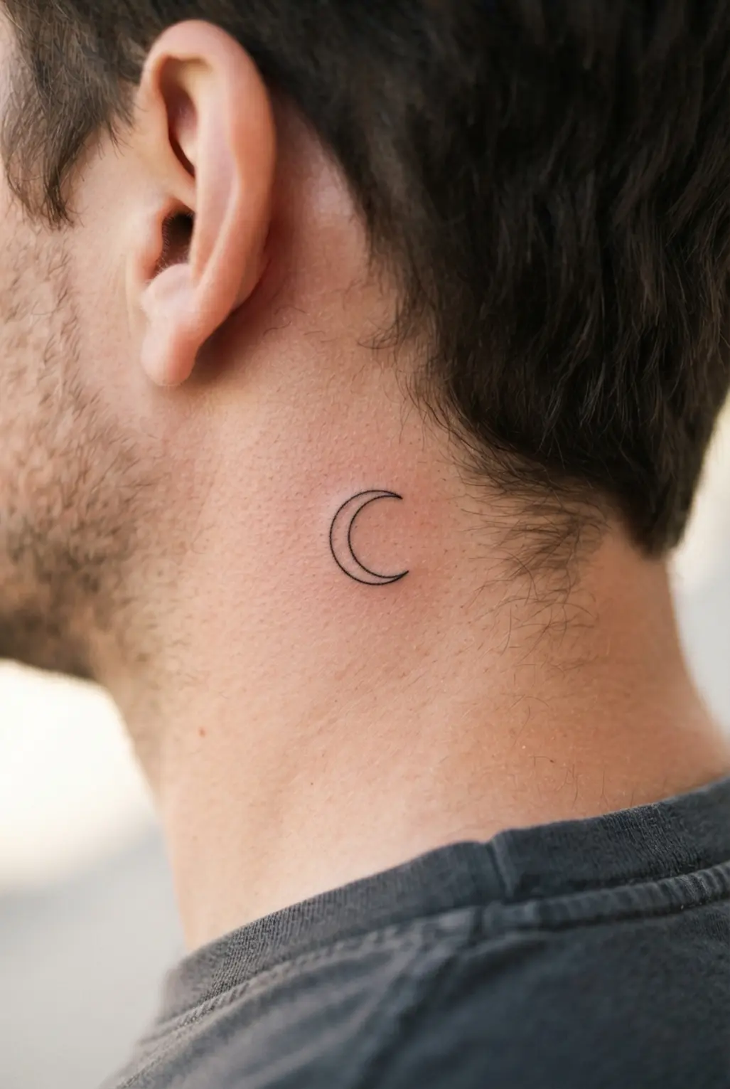 Subtle fine line tattoo placed discreetly behind the ear.