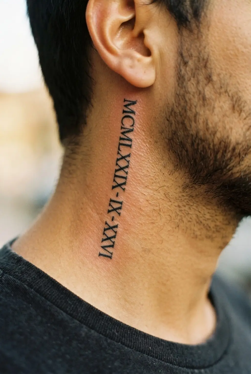 Vertical Roman numeral date tattoo on the side of the neck.