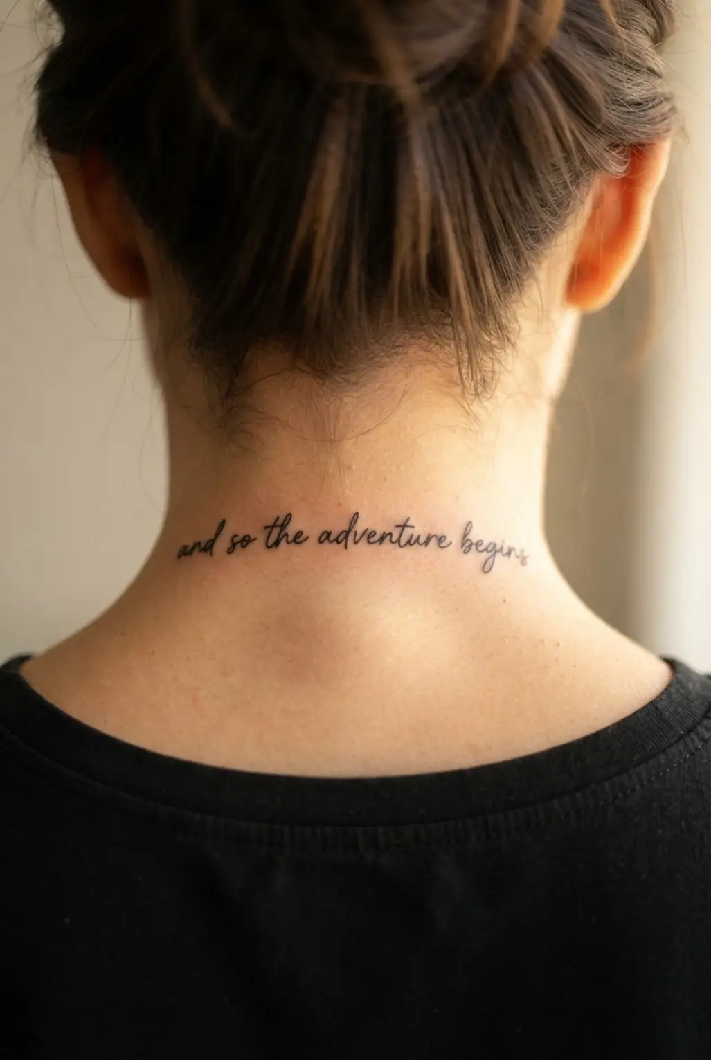 Delicate handwritten quote stretching across the nape with slim lettering and generous spacing.