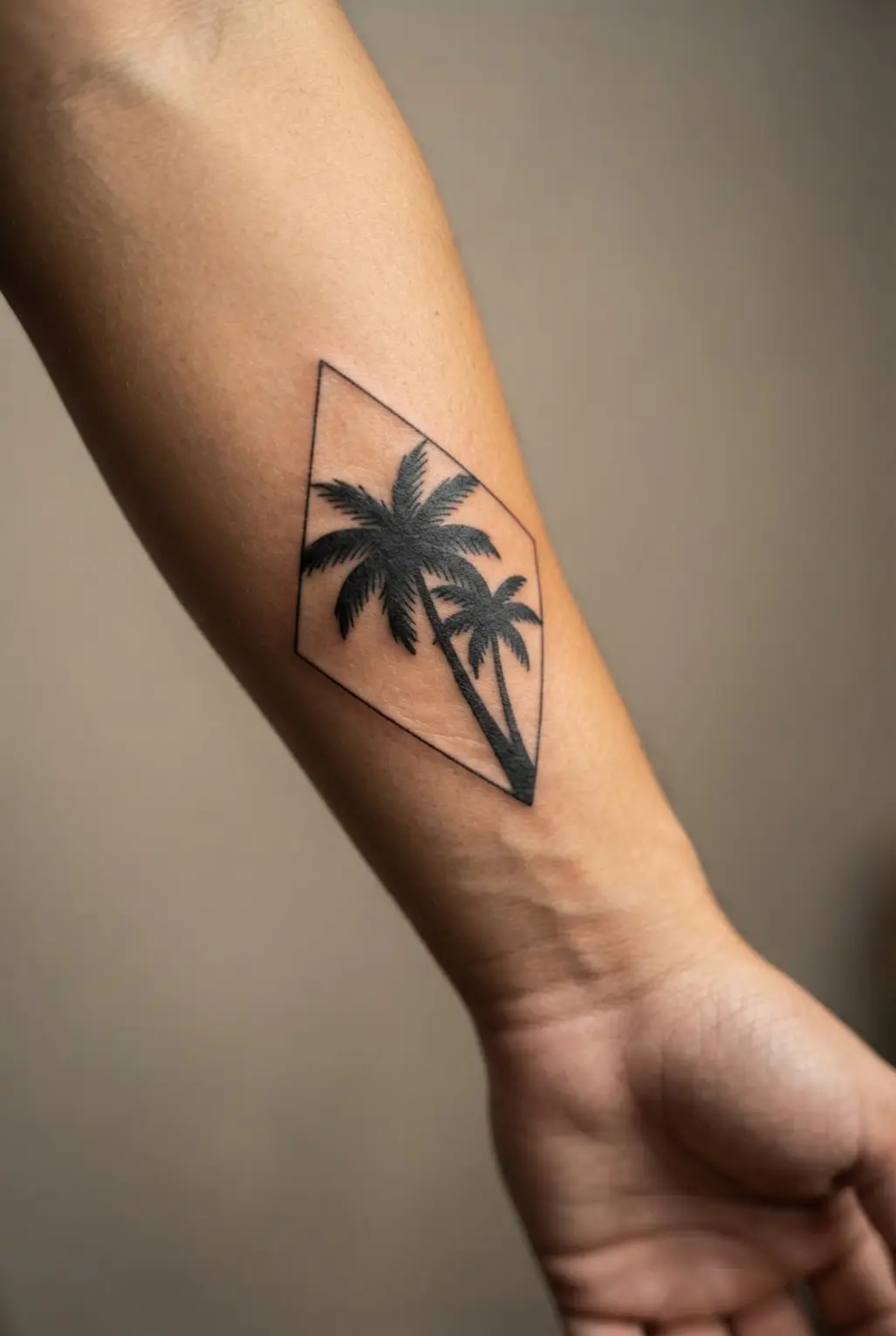 A solid black palm silhouette is centered inside a thin diamond frame on the outer arm.