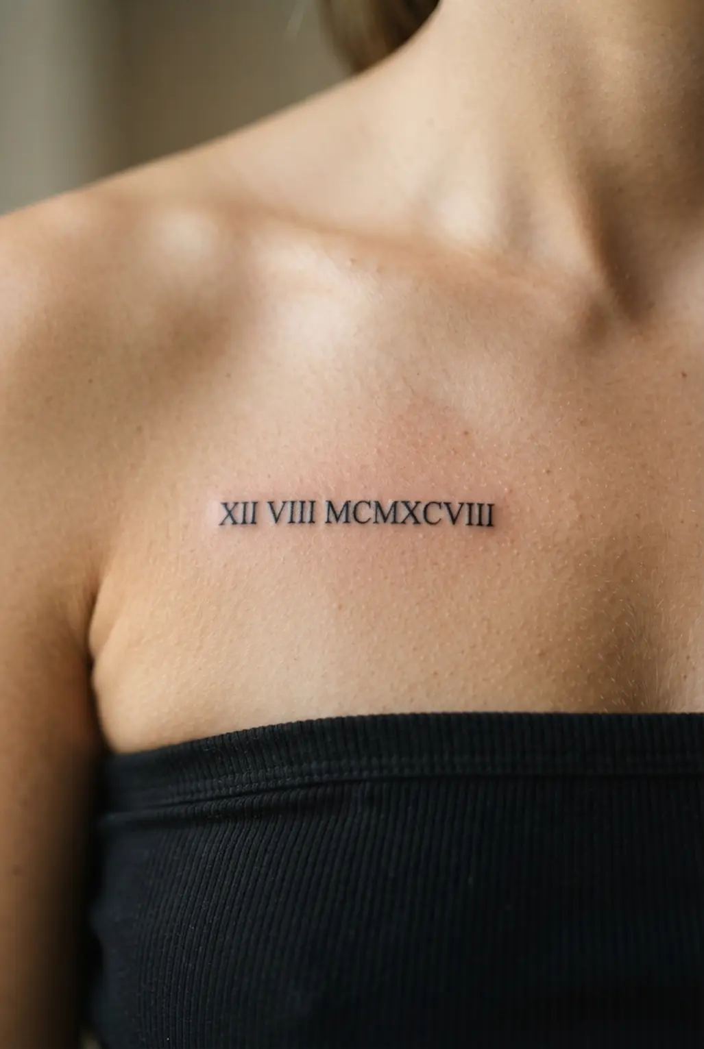 Small chest tattoos for women shown as tiny black Roman numerals beneath the collarbone.