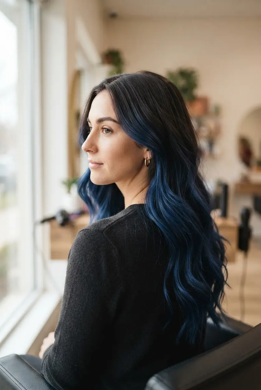 Long brunette waves with hand-painted midnight blue balayage through layered mid-lengths and ends.