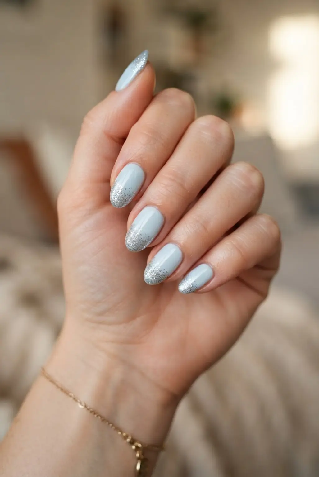 Light blue silver glitter tip nails with sparkling edges and almond-shaped outlines.