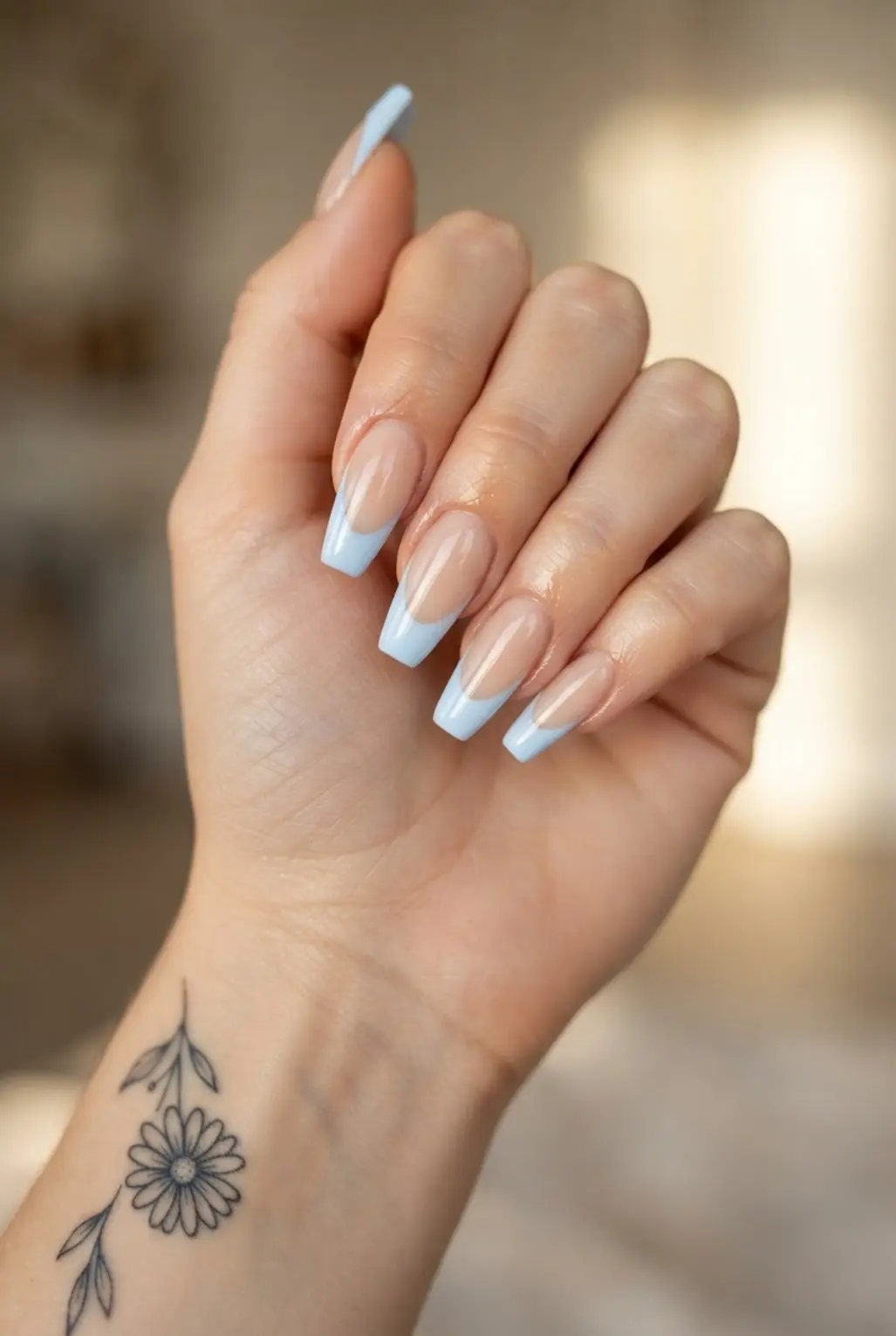 Light blue French tip coffin nails with nude bases, clean curved tips, and glossy topcoat.