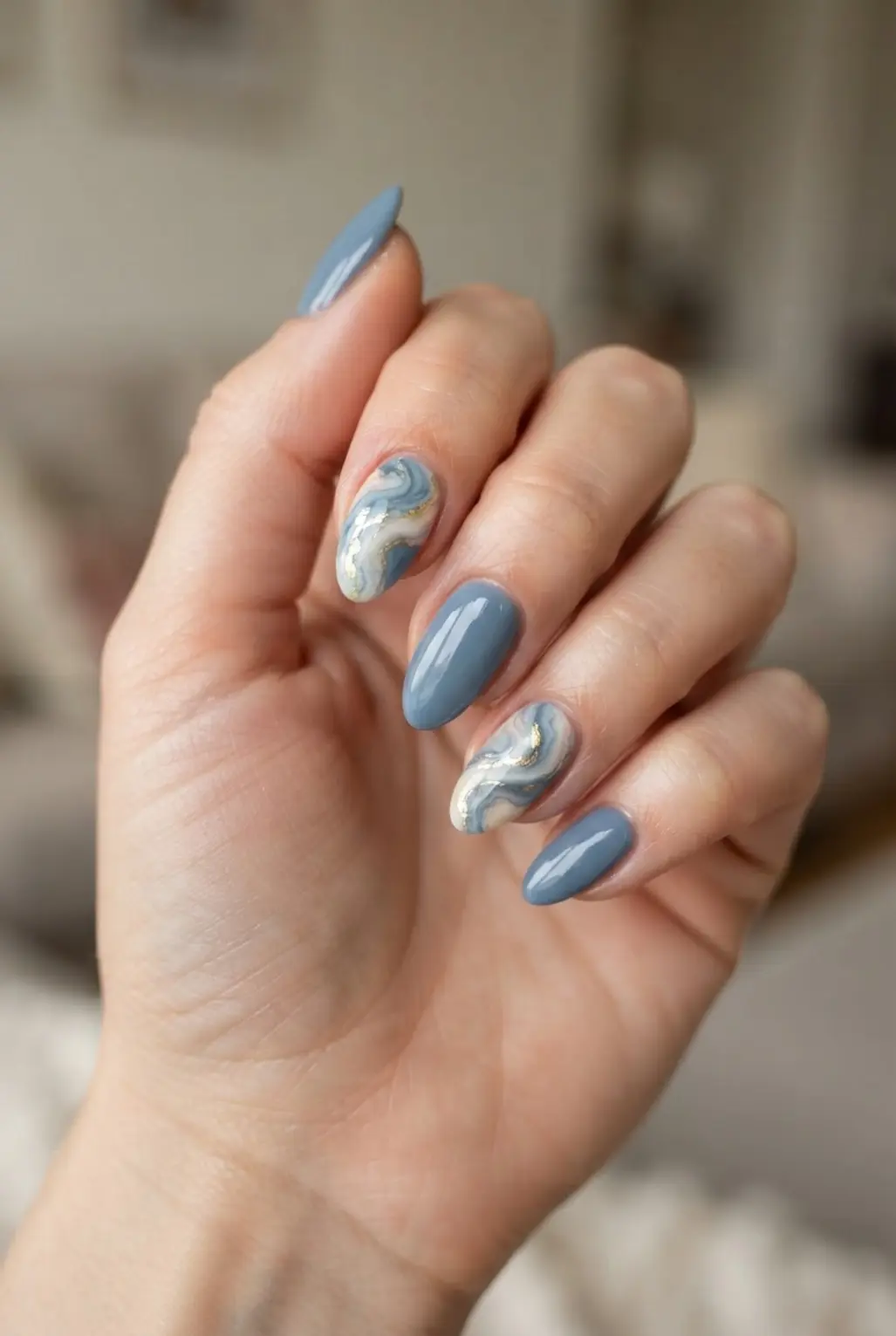 Dusty blue marble swirl accent nails with white veining and glossy solid blue nails.