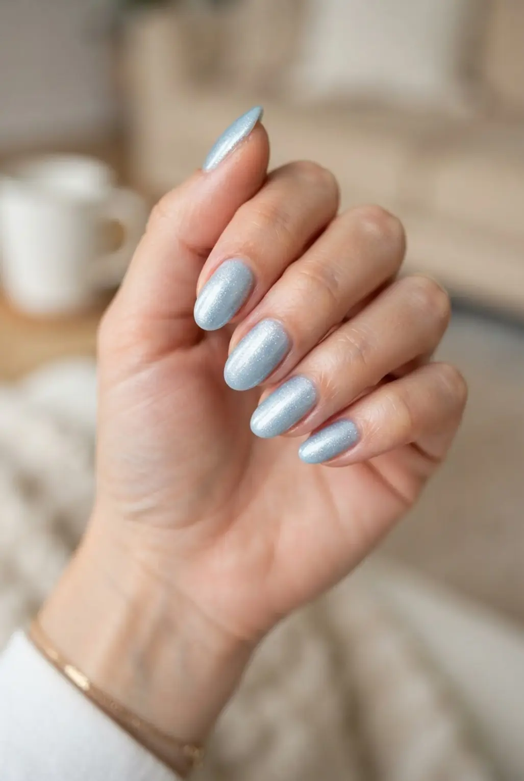 Ice blue shimmer oval nails with fine reflective particles and a cool glossy finish.